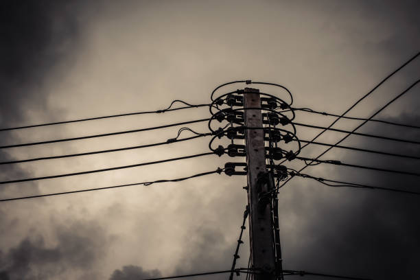 istock High voltage power pole with wires tangled on building background. 835736876