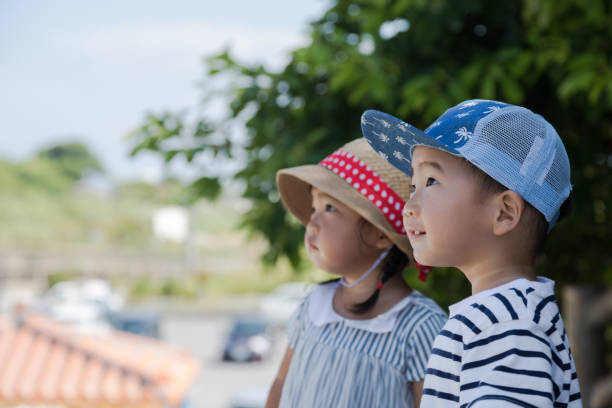 Twin brothers and sisters are having a good time with their mothers on the beach in Okinawa.
