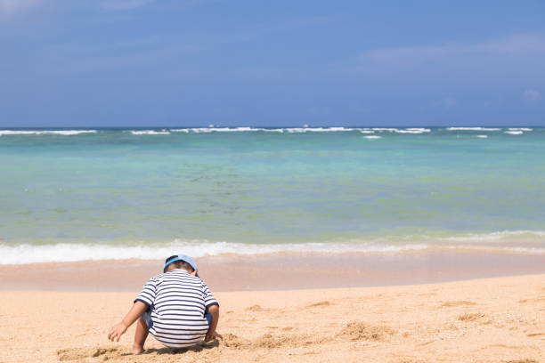 Twin brothers and sisters are having a good time with their mothers on the beach in Okinawa.