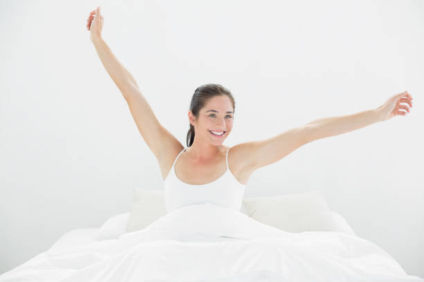 istock Smiling woman stretching arms in bed 835743726