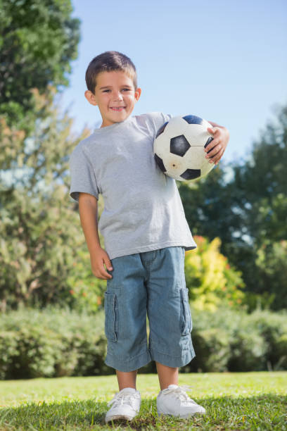 istock Young boy holding football 835746410