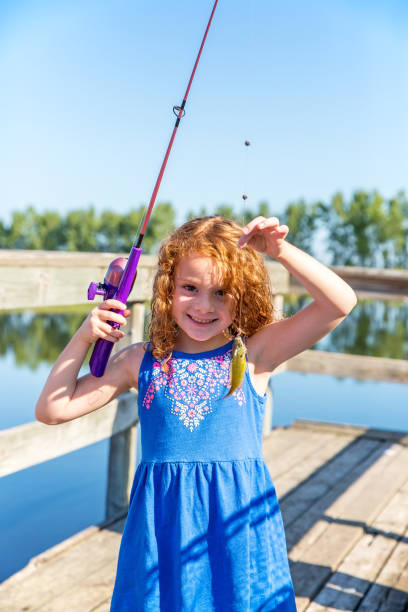 istock Young Girl Holding Up Sunfish She Just Caught 835746434