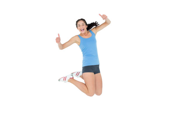 Active sporty young woman gesturing thumbs up over white background