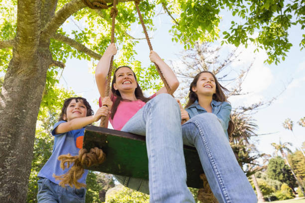 istock Kids pushing mother on swing 835754618