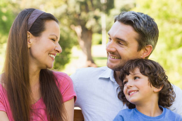 istock Smiling couple with son in park 835754860