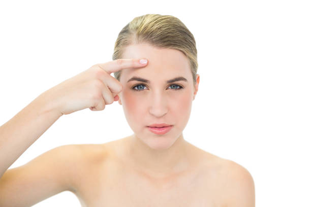 istock Pretty blonde pointing at wrinkle on her forehead 835754992