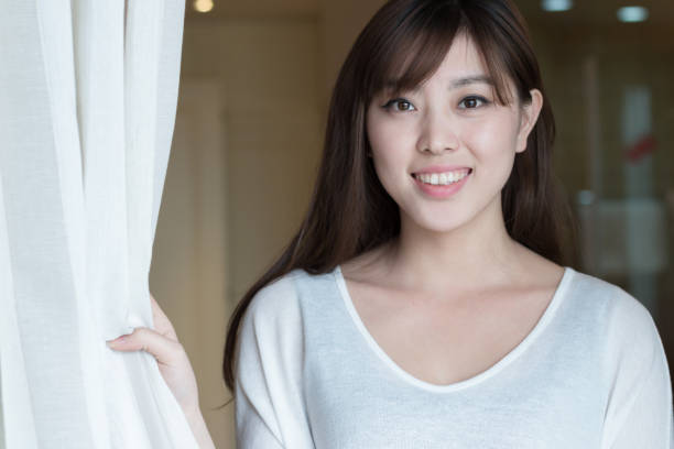 istock young beautiful asian stands near window 835756478