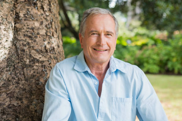 istock Happy retired man sitting on tree trunk 835757660
