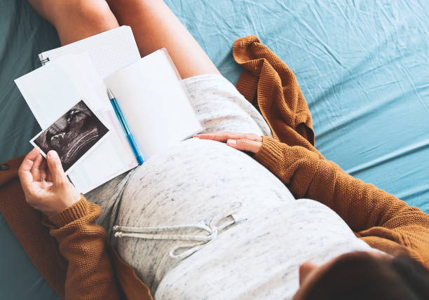la donna incinta prende appunti, guardando l'immagine degli ultrasuoni e i documenti medici. - human pregnancy obgyn women child foto e immagini stock