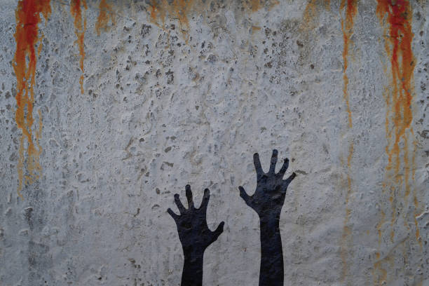 istock Corpse hands silhouette in shadow on concrete wall and blood background. 835757986