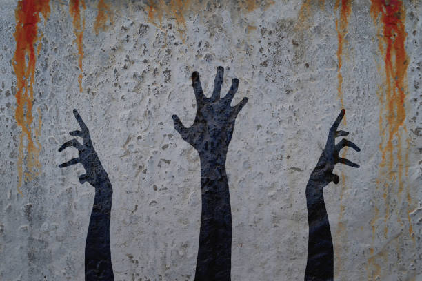 istock Three corpse hands silhouette in shadow on concrete wall and blood background. 835758020