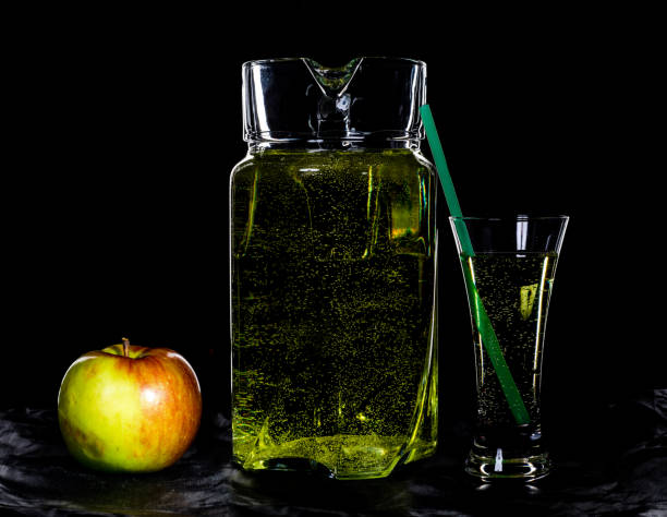 istock decanter and a glass of cider, apple on a black background 835758352