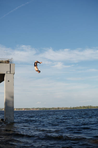 istock Man jumping into sea from pier 835758786