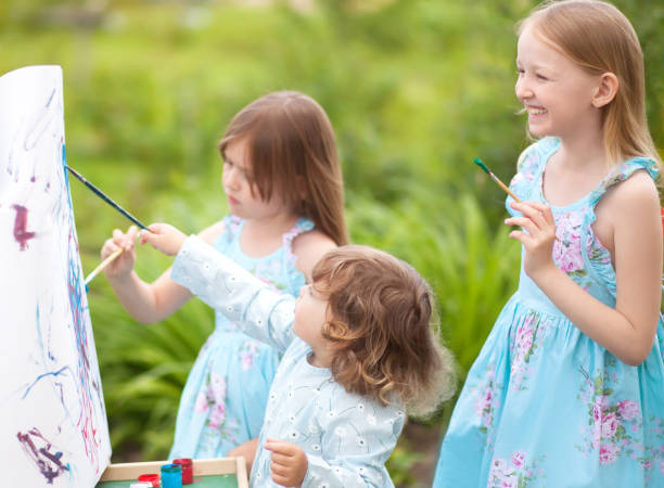 istock Three little sisters painting outdoors, having fun 835761626