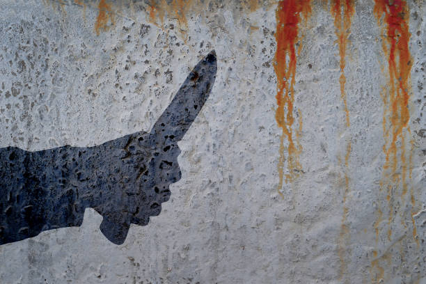 istock Human hand with killing knife silhouette in shadow on bloody cement wall background. 835764232