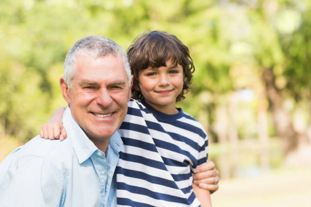 istock Grandfather and son smiling in park 835768112