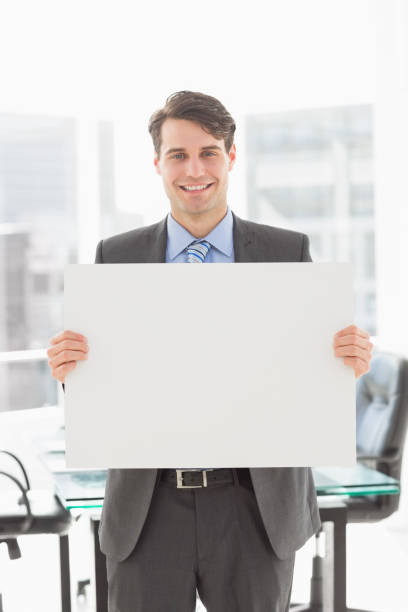 istock Handsome smiling businessman holding placard 835768650
