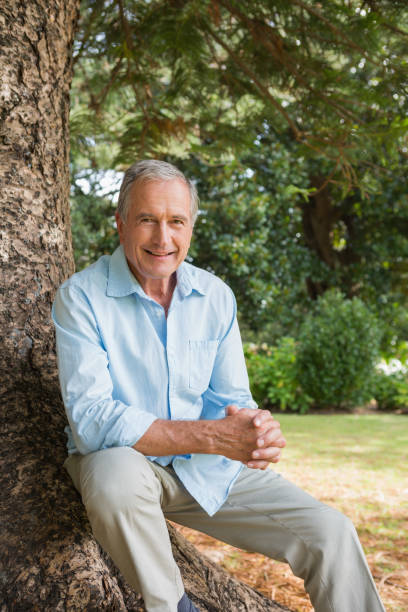 istock Happy mature man sitting on tree trunk 835772142