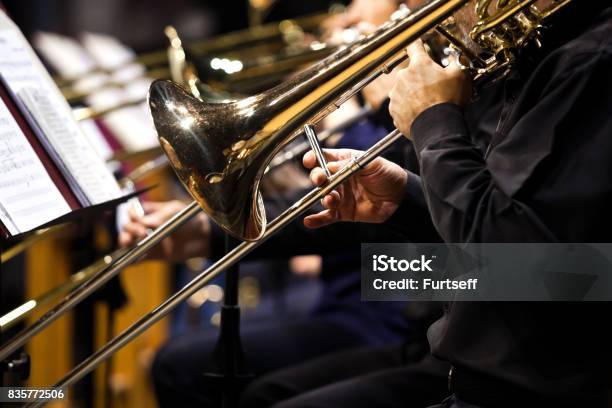 Trombones En Las Manos De Músicos De La Orquesta Foto de stock y más banco de imágenes de Trombón - Trombón, Orquesta, Latón