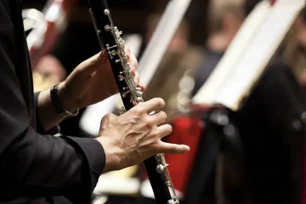 Hands of man playing the clarinet in the orchestra closeup