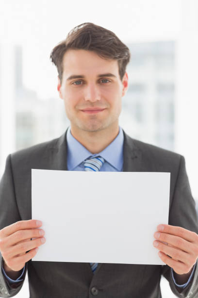 istock Smiling businessman holding blank page 835784060