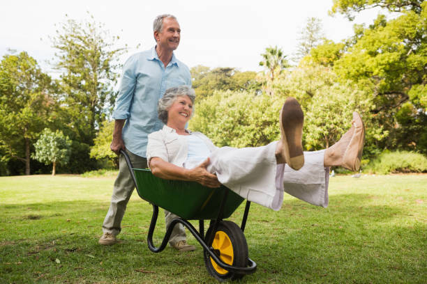 istock Smiling man pushing his wife in a wheelbarrow 835791172