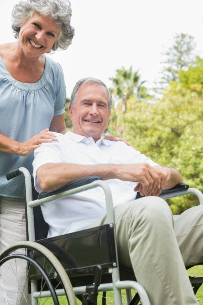 istock Cheerful mature man in wheelchair with partner 835791254