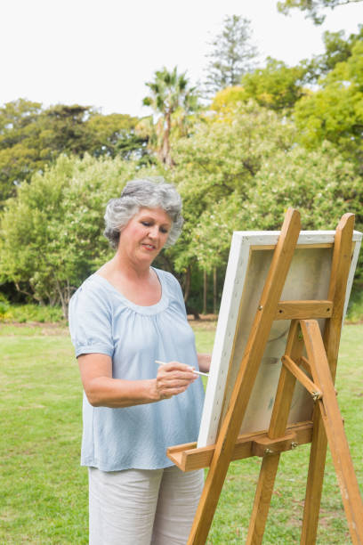 istock Happy retired woman painting on canvas 835791324