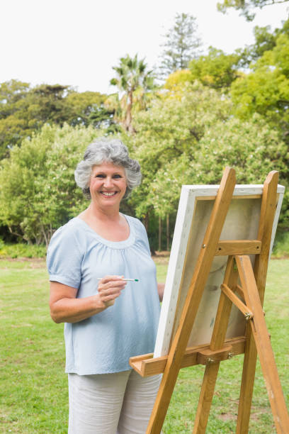 istock Cheerful retired woman painting on canvas 835791342