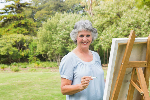 istock Smiling retired woman painting on canvas 835791352