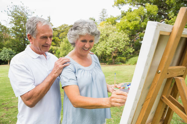 istock Content retired woman painting on canvas and talking with husband 835791492