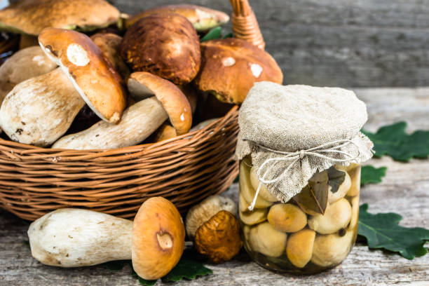 istock Marinated mushrooms - boletus pickled in jar on rustic background, preserves preparing 835802050