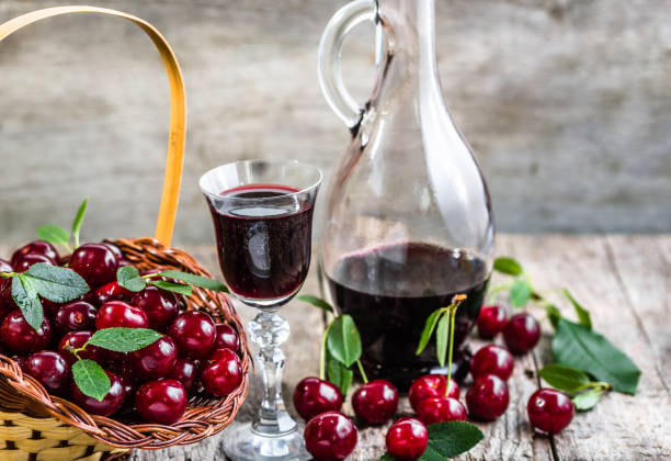 와인과 나무 테이블에 빈티지 유리병 유리. 체리 과일에서 �만든 달콤한 알코올 - juice carafe glass decanter 뉴스 사진 이미지