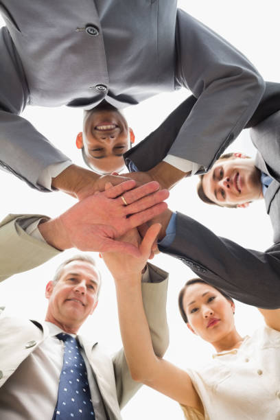 istock Business team smiling down at the camera with hands together 835810204
