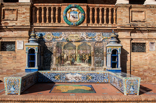 Seville, Andalusia, Spain - April, 14, 2016: bench and ceramic ornaments dedicated in Plaza de Espana, the most famous square of Seville, to 48 Spanish provincial capitals with maps, mosaics depicting historical events and coats of arms