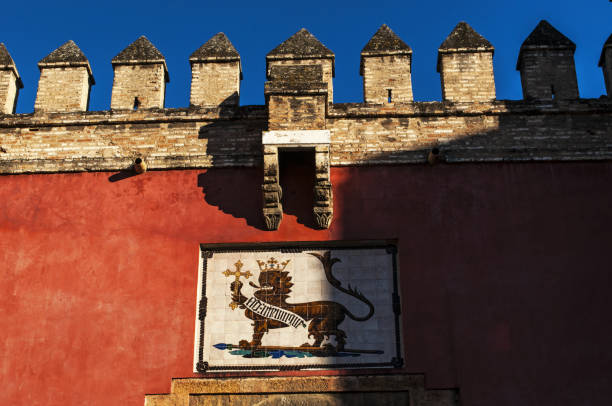 испания: знак алькасар севильи, знаменитый королевский дворец, первоначально разработанный мавританскими мусульманскими королями - coat of arms nobility lion spain стоковые фото и изображения