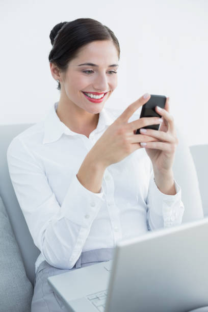 istock Smiling well dressed woman using cellphone and laptop 835825208