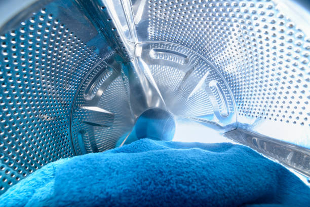 Modern washing machine Modern washing machine loaded with blue towel washing machine drum stock pictures, royalty-free photos & images
