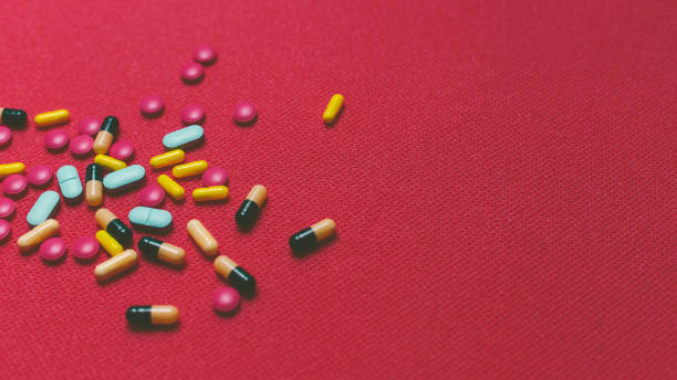 istock Different Colorful Pills, Tablets And Capsules On Red Background 835833926