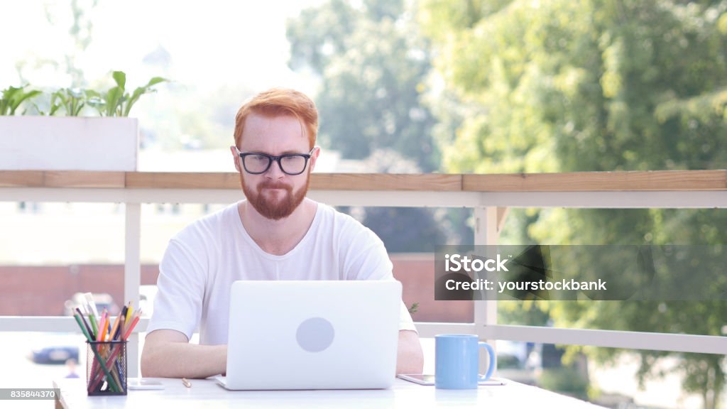 Upset Man after Failure of Project, Loss, Sitting in Outdoor Office, Red Hairs Acting - Performance Stock Photo