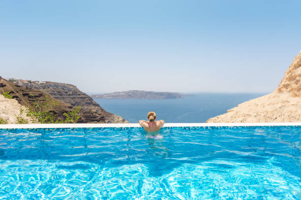 frau in einem infinity-pool im resort spa - sea swimming greece women stock-fotos und bilder