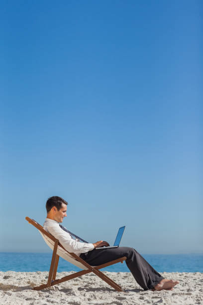istock Young businessman on his deck chair using his laptop 835853662