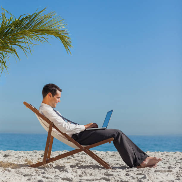 istock Young businessman on his beach chair using his laptop 835853792