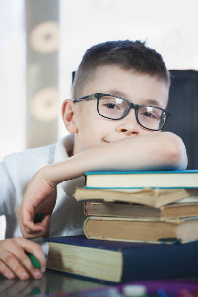 istock Beautiful schoolboy doing homework at home 835860472