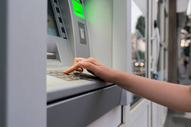 istock Woman's hand entering the code at the ATM at night 835861184