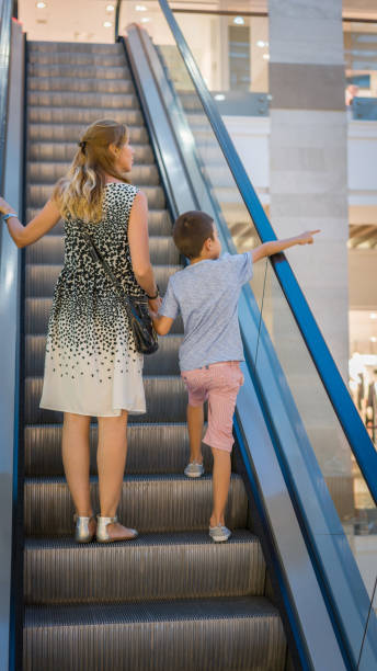 istock Mom and son on escalator 835871372