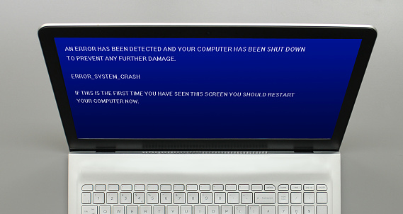 A laptop demonstrating a fatal error that has caused a 'blue screen of death' on a generic device with fictional software/operating system