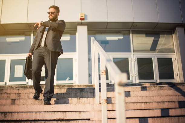 istock Young businessman checking the time and being late 835874760