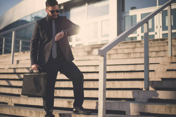 istock Young businessman checking the time and being late 835874846
