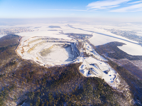 Aerial view to quarry. Industrial landscape in wintertime. Heavy industry with problems from cold weather and snow calamity.